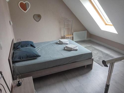 une chambre avec un lit avec des oreillers bleus dessus dans l'établissement Appartement Le Marceau, proche de la Mer., au Crotoy