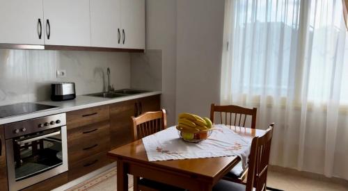 a kitchen with a table with a bowl of bananas on it at Kylian Apartments in Sarandë