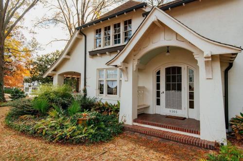 a white house with a porch and a door at The Cinderella House in Greensboro