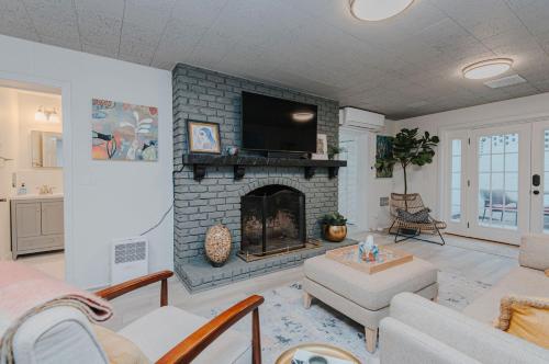 a living room with a fireplace with a tv at Marys Gatehouse Garden Apartment in Greensboro