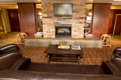 een woonkamer met een bank en een open haard bij Holiday Inn Express & Suites Drayton Valley by IHG in Drayton Valley