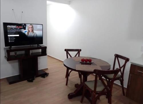 sala de estar con mesa y TV de pantalla plana en Qhapac Casa San blas 1, en Cusco