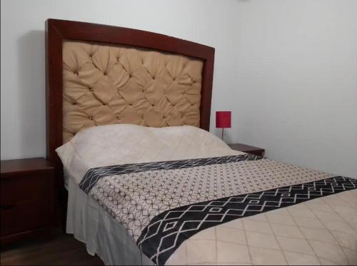 1 cama en un dormitorio con cabecero grande en Qhapac Casa San blas 1, en Cusco