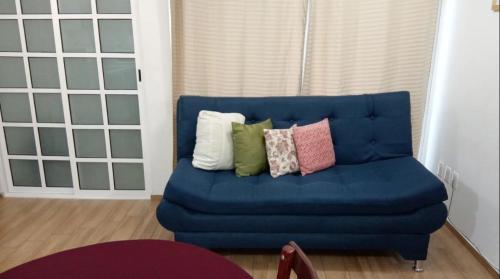 un sofá azul con almohadas en la sala de estar en Qhapac Casa San blas 1, en Cusco