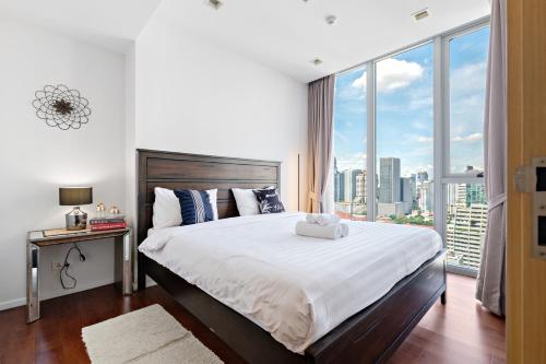 a bedroom with a large bed with a large window at The Echelon Sukhumvit 11 by LeFoyer in Bangkok