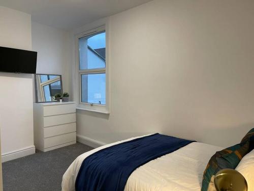 - une chambre blanche avec un lit et une fenêtre dans l'établissement Modern 6bedroomall ensuite in Birkenhead Free Parking and Wifi, à Wallasey