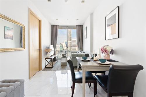 a dining room with a table and a couch at The Echelon Sukhumvit 11 by LeFoyer in Bangkok