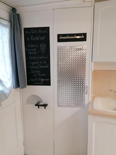 - une cuisine avec un tableau noir sur un mur à côté d'un évier dans l'établissement Le Cottage, à Rochefort