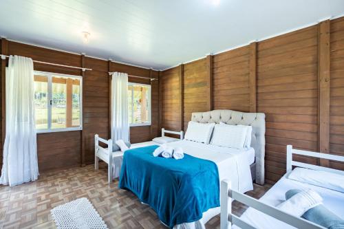 Tempat tidur dalam kamar di Celeiro da Lagoa - Chalé confortável em meia à Natureza A apenas 8 km de distância da praia central de Balneário Picarras e a 15 Parque Beto Carrero World
