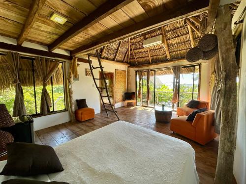 a bedroom with a bed and a room with windows at Miravalle Eco Surf in Sonsonate