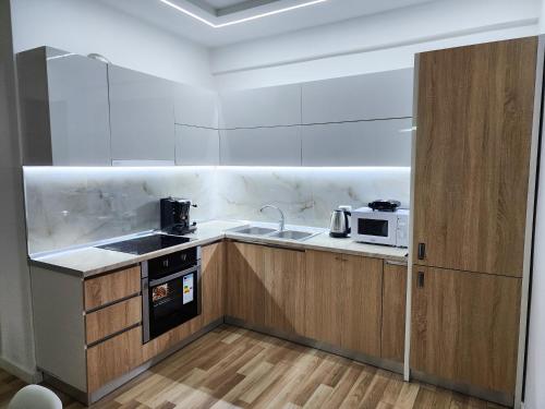 eine kleine Küche mit einer Spüle und einer Mikrowelle in der Unterkunft 2E Apartment Myslym Shyri in Tirana