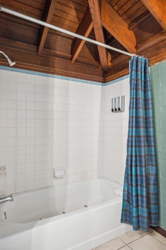 a bath tub with a plaid shower curtain in a bathroom at THE CARRICK in Bisbee