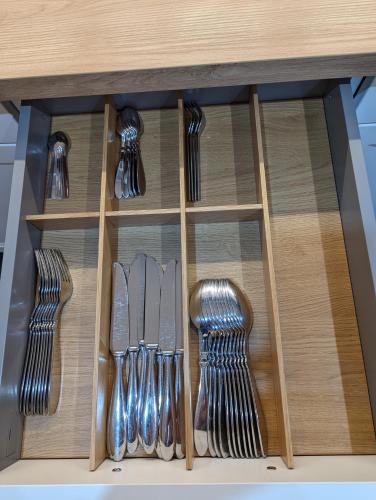 a drawer with knives and utensils on a table at Chic & Blick Die Ferienwohnung in Ebermannstadt