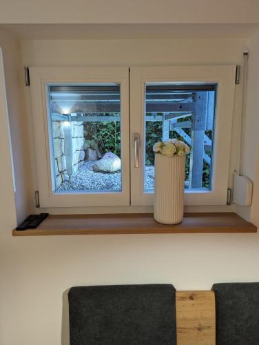 two windows in a room with a trash can at Chic & Blick Die Ferienwohnung in Ebermannstadt