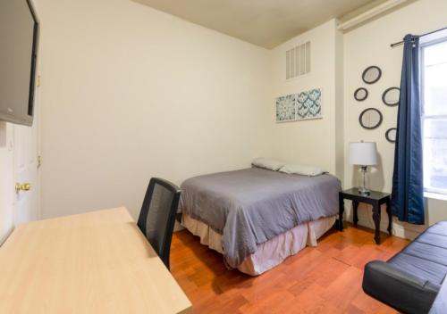 een slaapkamer met een bed en een tafel. bij Magnificent 2 BD 1 BR At Mid West in New York