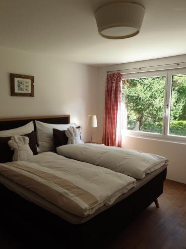 a large bed in a bedroom with a window at Apartment Windward in Zermatt