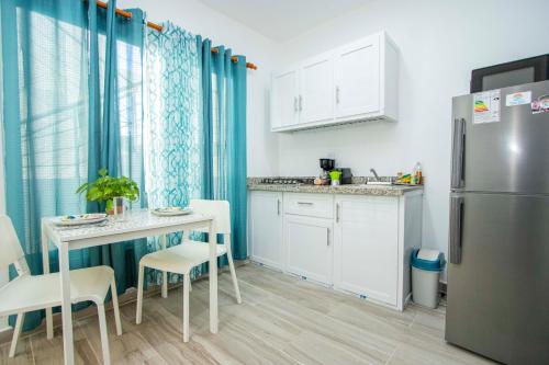 a small kitchen with a table and a refrigerator at Cape Coral 3 in Cabrera