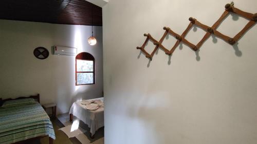 a room with a bed and a table and a window at Hospedagem do Sítio in Lençóis