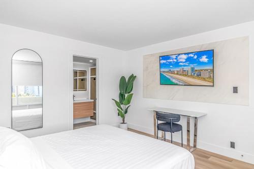 a white bedroom with a bed and a desk at Fifth and Ocean in Myrtle Beach