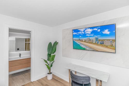 a white room with a table and a television on a wall at Fifth and Ocean in Myrtle Beach