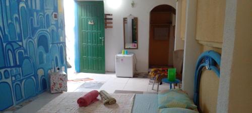 a room with a green door and a refrigerator at Gruta da Praia 1 in Saquarema
