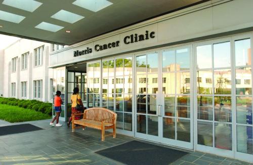 two people standing outside of a music cancer clinic at University Inn Duke in Durham