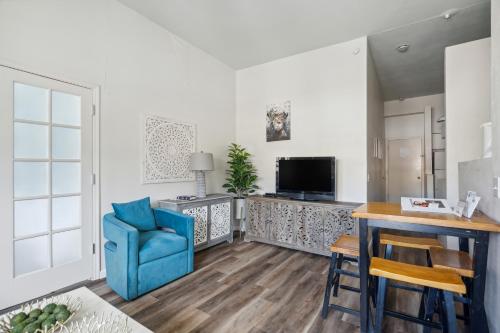 a living room with a blue chair and a television at THE CARRICK in Bisbee