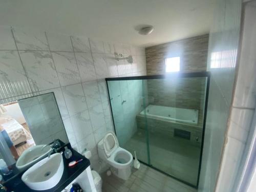 a bathroom with a sink and a toilet and a shower at Casa perfeita pra fim de semana e feriadões in Vitória de Santo Antão