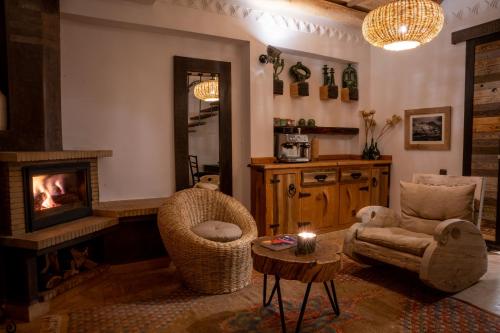 a living room with a fireplace and a chair at Eden Boutique Hotel in Tamellalt