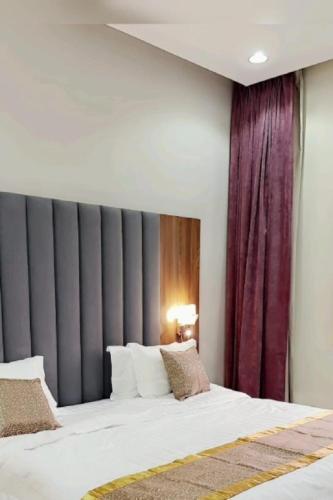 a bedroom with a large bed with a red curtain at شاليهات سرايا ان لبيوت العطلات in Jazan