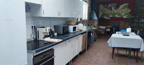 a kitchen with white cabinets and a table in it at Casa El Drago in Las Palmas de Gran Canaria