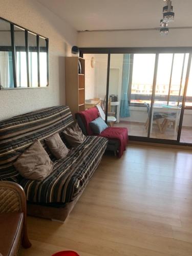 un salon avec un canapé et une chaise dans l'établissement APPARTEMENT VUE LAC MARIN ET CANIGOU, au Barcarès