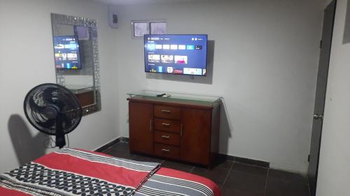 a room with a fan and a dresser and a tv at El Encanto III - ApartaSuite in Barranquilla