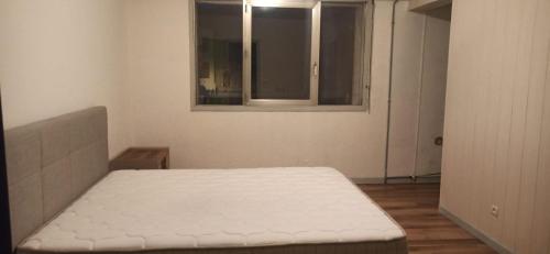 ein Schlafzimmer mit einem Bett in einem Zimmer mit einem Fenster in der Unterkunft appartement hôtel in Ligny-en-Barrois
