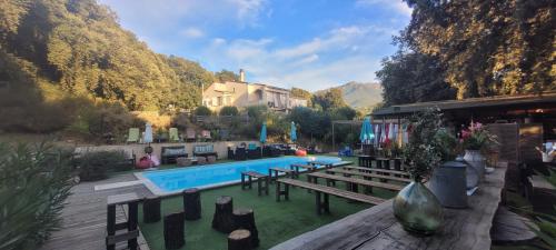 une arrière-cour avec une piscine, une maison et des arbres dans l'établissement Gites San Austinu, à Petreto-Bicchisano