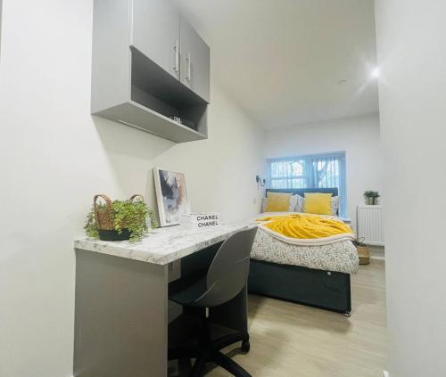 a kitchen with a desk and a bed in a room at Sleek & Stylish Stretford Studio for Two in Manchester