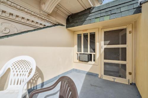 a porch with a white chair and a window at THE CARRICK in Bisbee