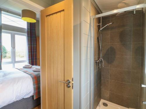 a bathroom with a shower and a bedroom with a bed at Willow Lodge in Newark upon Trent