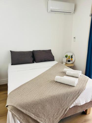 a bedroom with a bed with two towels on it at Studio & piscine in La Saline les Bains