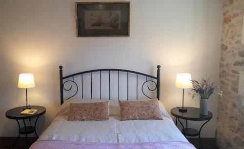 a bedroom with a bed with two tables and two lamps at Le Marais in Chasseneuil-sur-Bonnieure