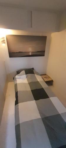 a bedroom with a bed with a checkered blanket at Stacaravan op de paardenboerderij Sneek in Sneek