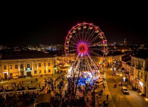 a ferris wheel in a city at night at Hotels-Widok Rynek - Centrum &Parking -fak VAT in Kielce