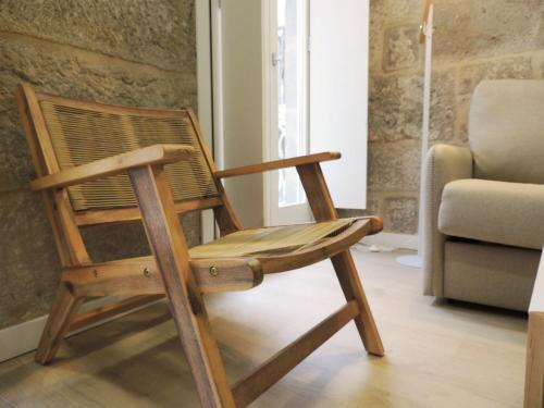 a wooden rocking chair in a living room with a couch at NOiTE 1 in Pontevedra