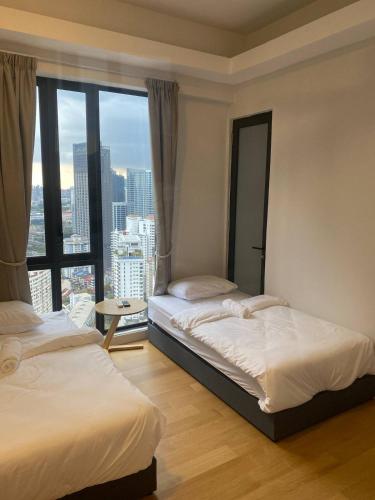 a bedroom with two beds and a large window at SS KL Sentral by NomadNest in Kuala Lumpur