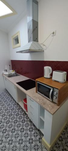 eine Küche mit Theke und Mikrowelle in der Unterkunft CASA MARIANA 1 - Viver a Vila in Sintra