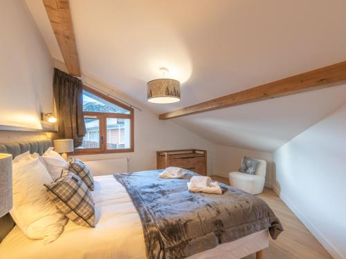une chambre avec un grand lit et une fenêtre dans l'établissement Appartement neuf, spacieux, proche pistes et centre, parking et wifi inclus - FR-1-645-61, à Huez
