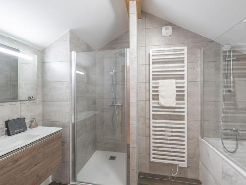 uma casa de banho com um chuveiro e um lavatório. em Appartement Huez, 4 pièces, 6 personnes - FR-1-645-61 em LʼHuez
