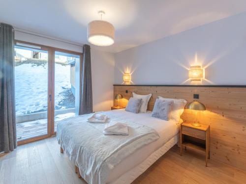 une chambre avec un grand lit et une grande fenêtre dans l'établissement Appartement Neuf au Vieil Alpe - 108m², 3 Chambres, Proche Pistes et Centre - FR-1-645-69, à Huez