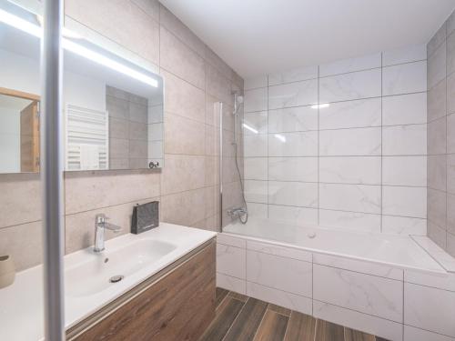 une salle de bain blanche avec une baignoire et un lavabo dans l'établissement Appartement Neuf au Vieil Alpe - 108m², 3 Chambres, Proche Pistes et Centre - FR-1-645-69, à Huez