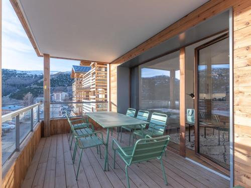 - un balcon en bois avec une table et des chaises dans l'établissement Appartement Neuf au Vieil Alpe - 108m², 3 Chambres, Proche Pistes et Centre - FR-1-645-69, à Huez